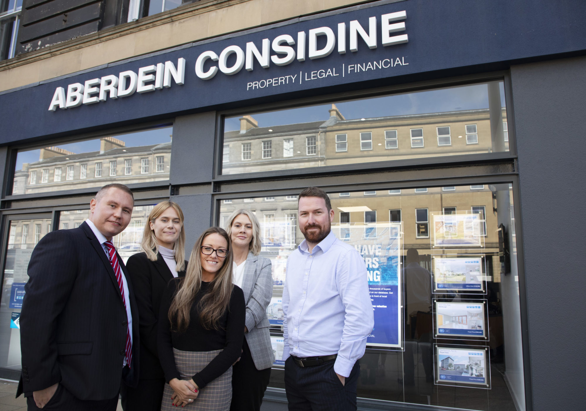 group standing outside of property business