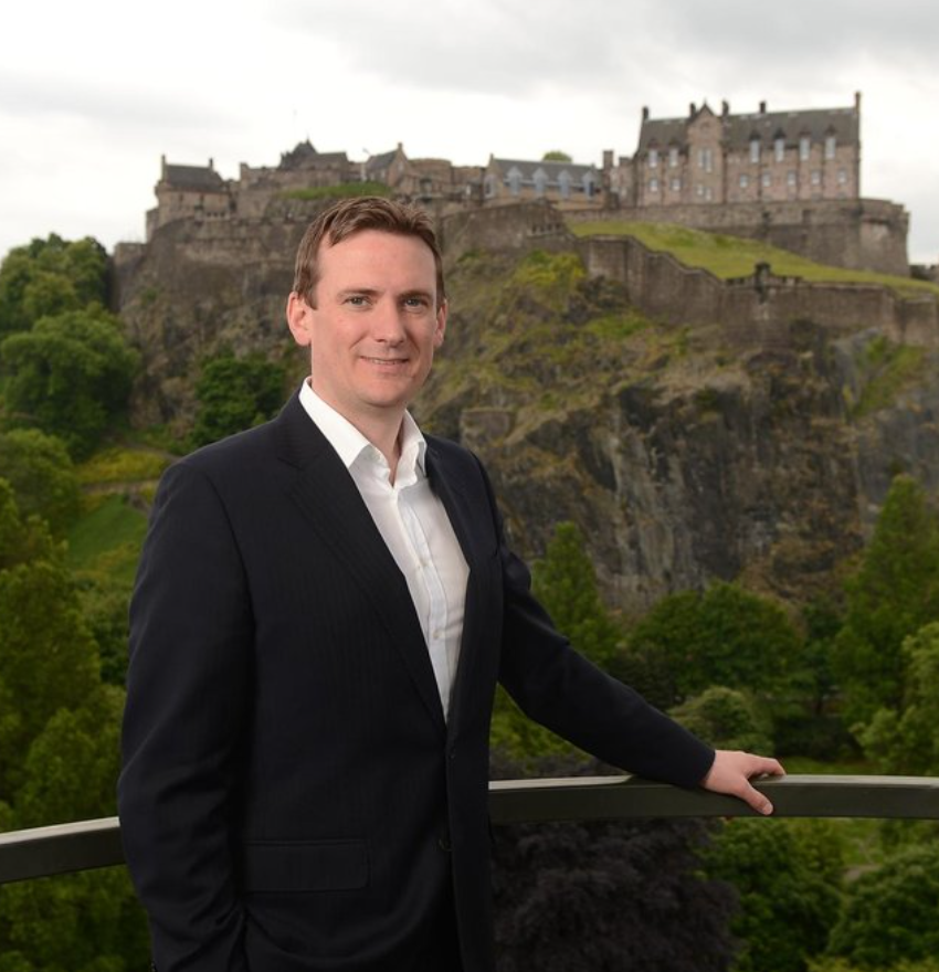 man standing in front of Edinburgh Castle